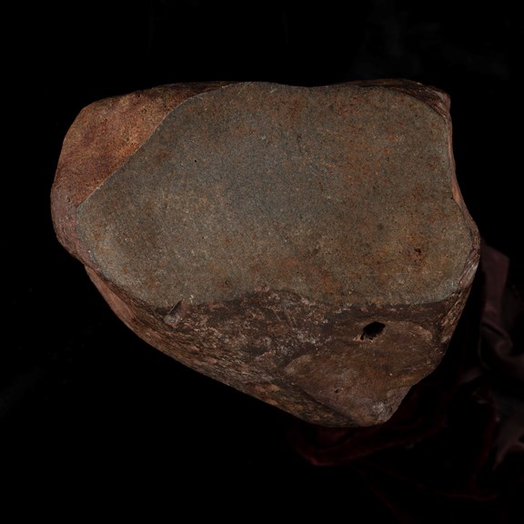 A reddish rock with a hole in it. 